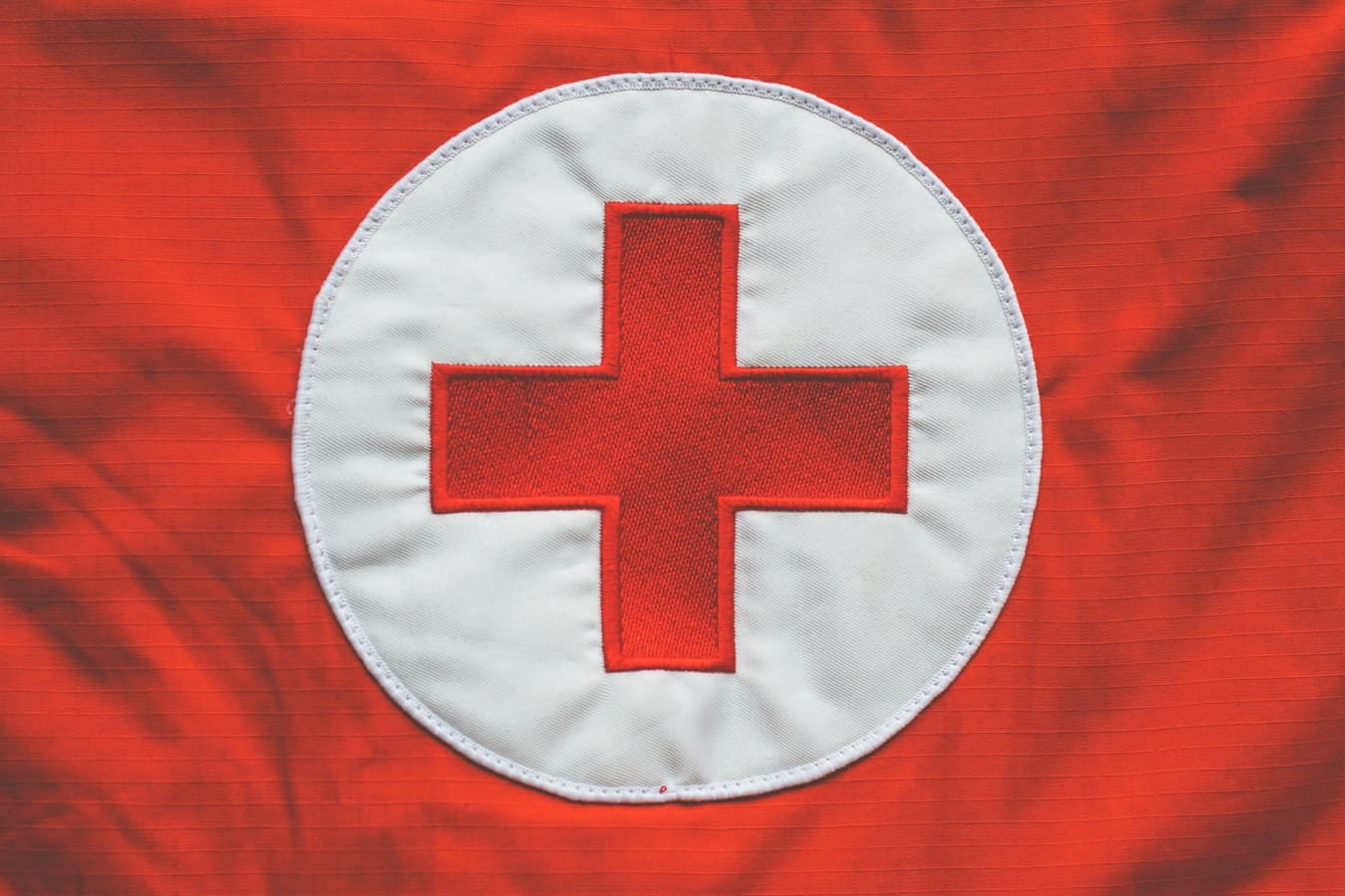 Logo de la Croix Rouge cousu sur un uniforme de secouriste